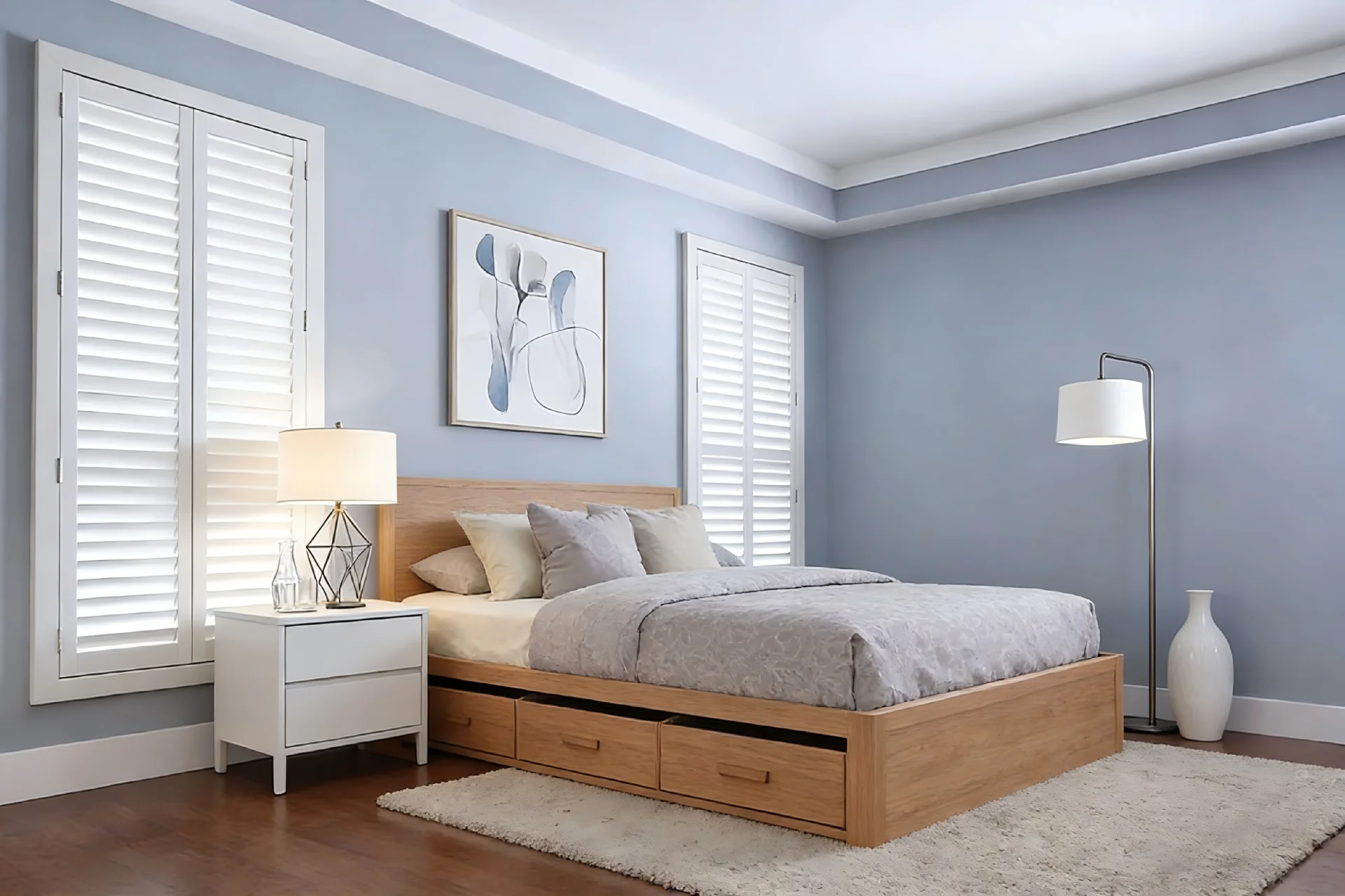 Modern bedroom featuring light blue walls, a wooden bed with storage drawers, white nightstand, and floor lamp.