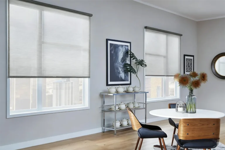 Contemporary dining room with wooden chairs, white table, art, and neutral window blinds, featuring decorative plants and teapots.