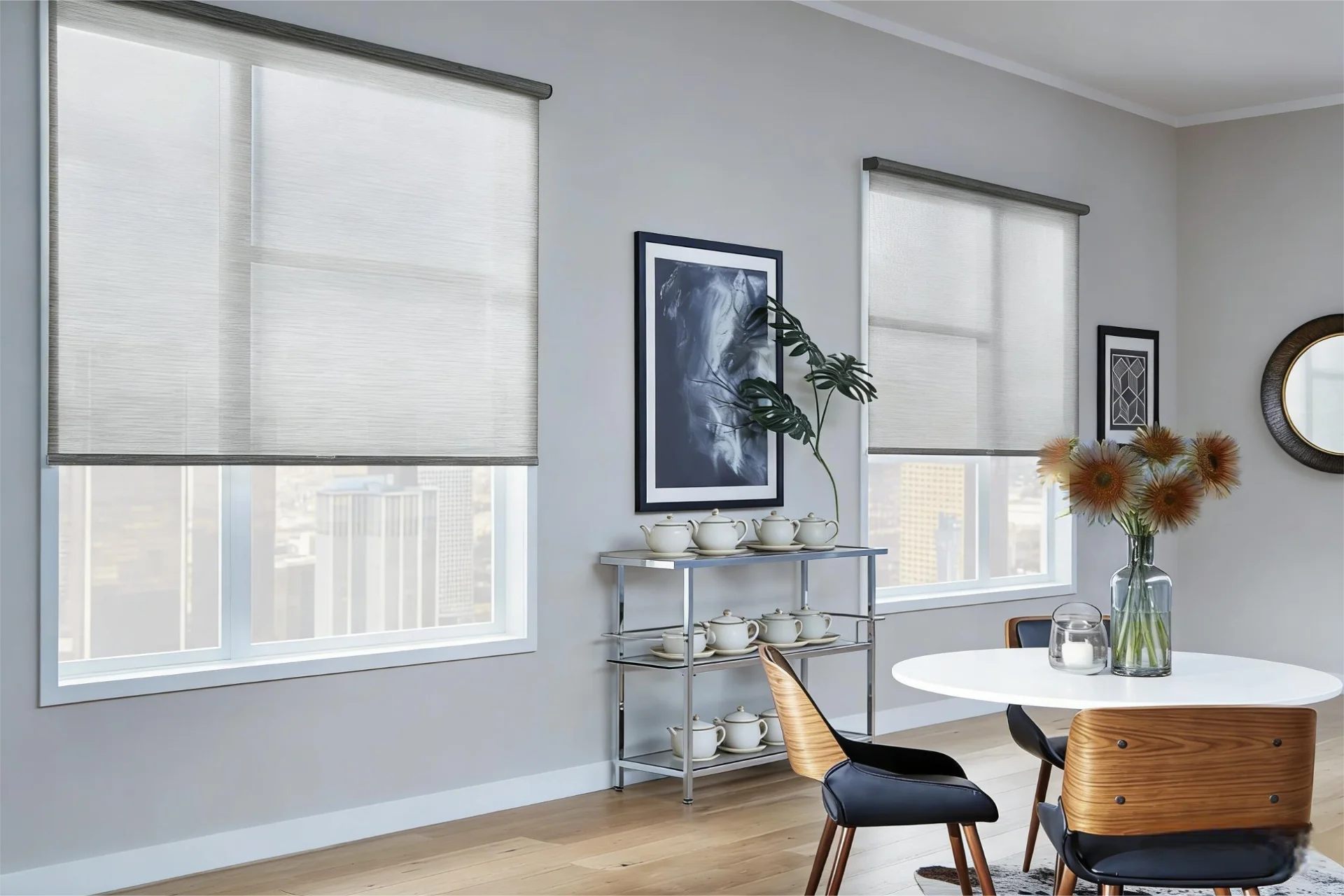 Contemporary dining room with wooden chairs, white table, art, and neutral window blinds, featuring decorative plants and teapots.