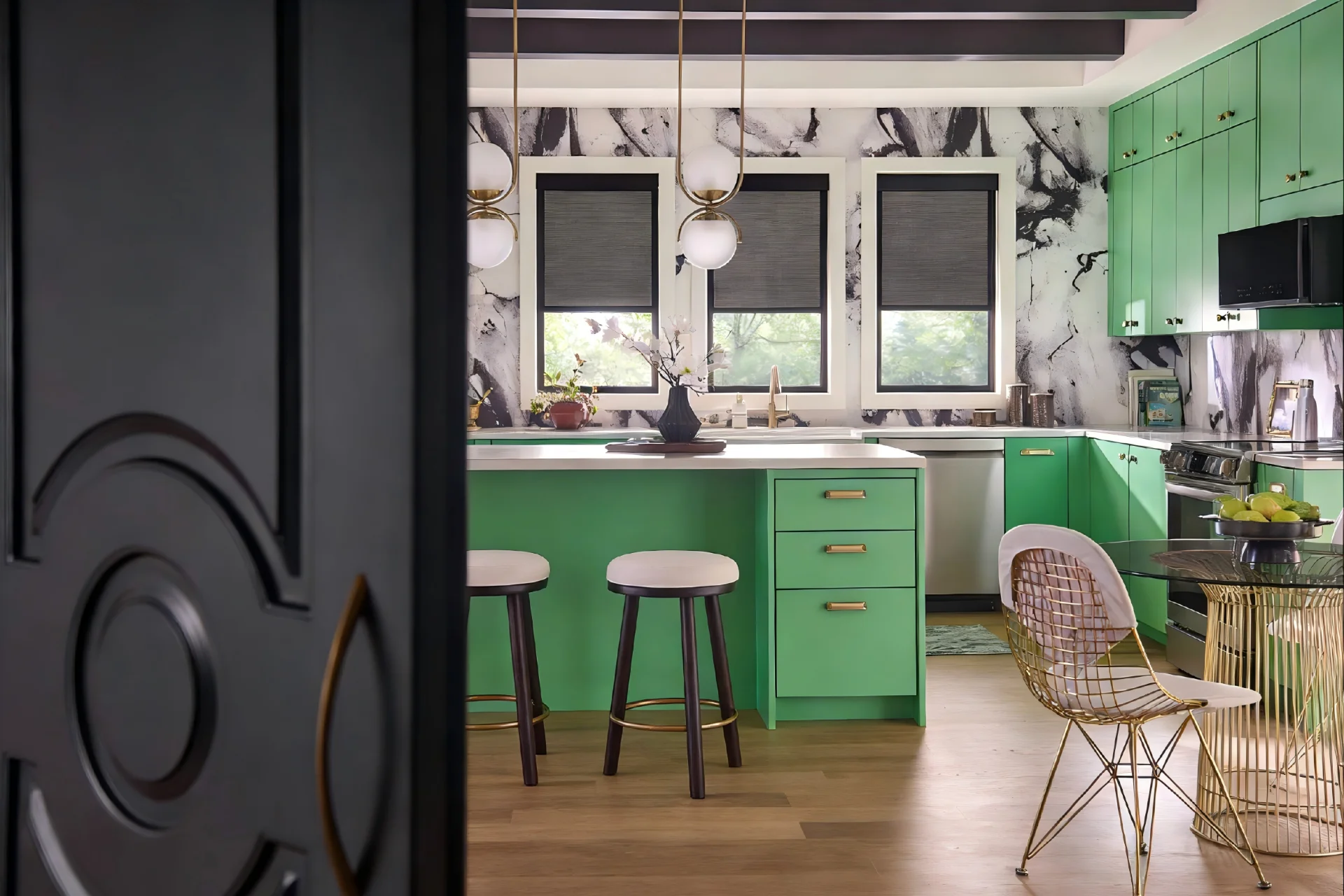 Contemporary kitchen featuring bright green cabinets, marble wall accents, and modern light fixtures. Central island with stools.
