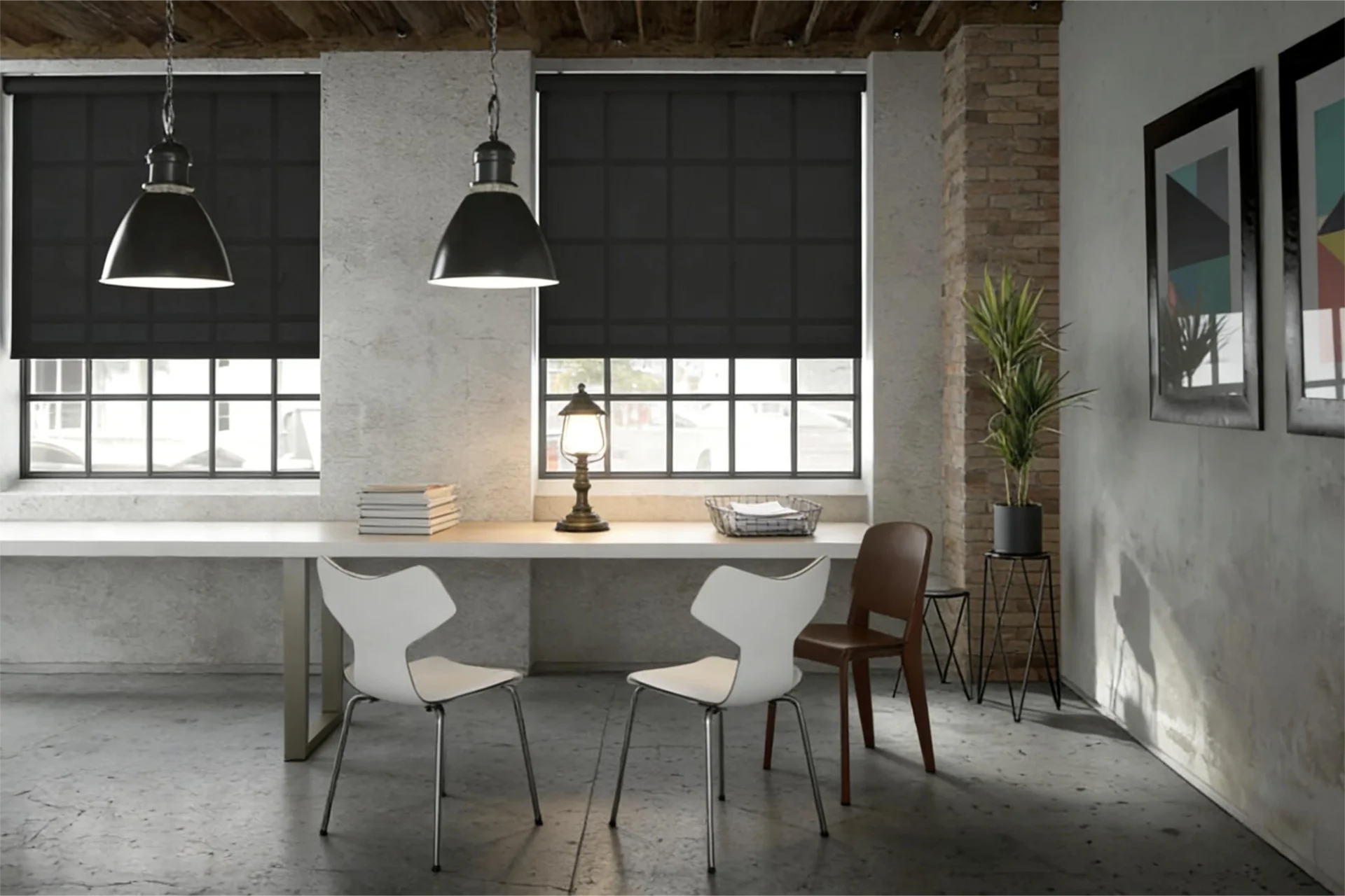 Office interior featuring exposed brick wall, pendant lights, black window shades, white desk, chairs, and a plant in a corner.