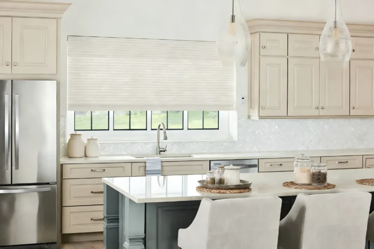 Modern kitchen featuring clean lines, beige cabinets, stainless steel appliances, and pendant lighting over a central island.