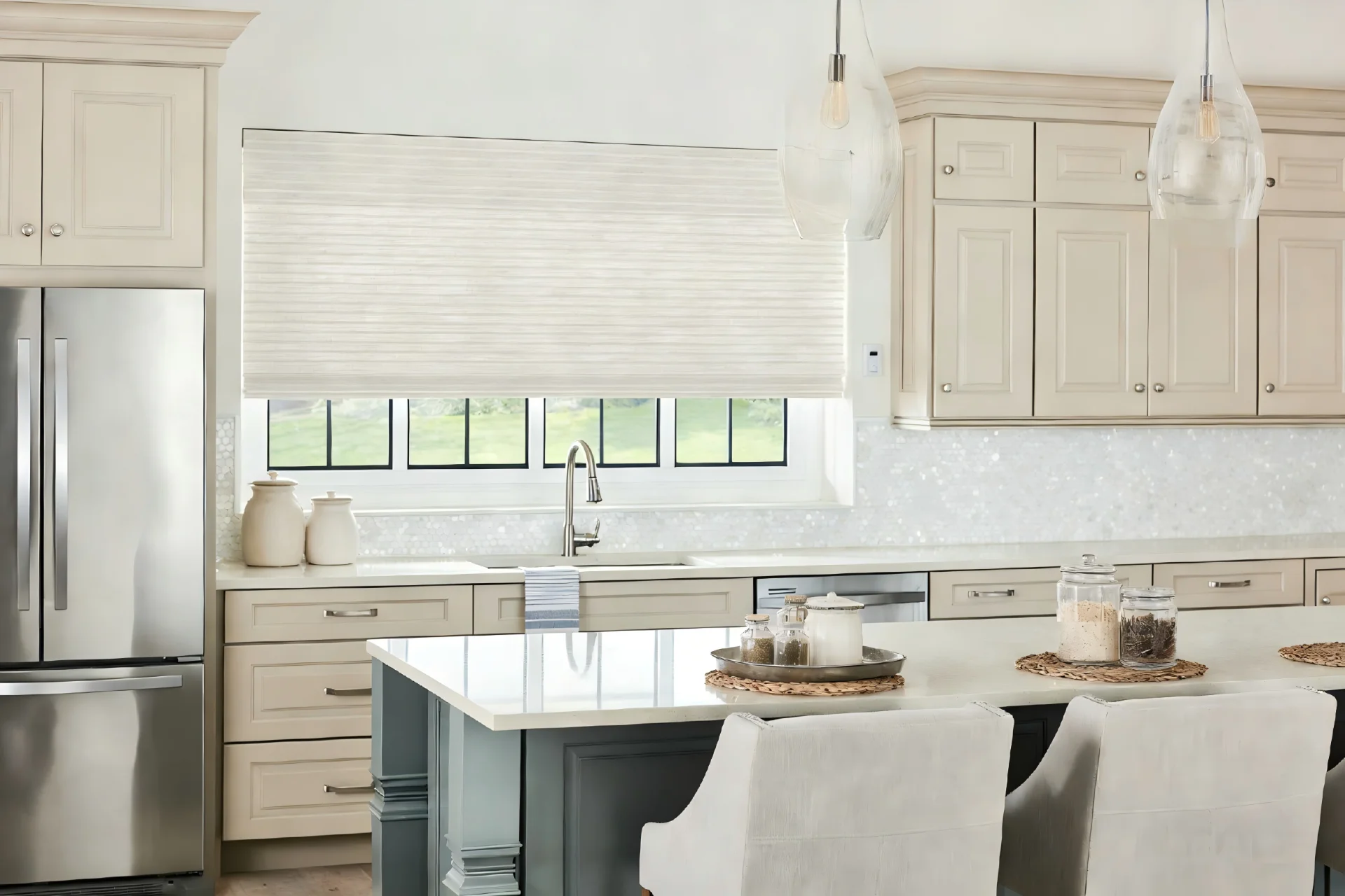 Modern kitchen featuring clean lines, beige cabinets, stainless steel appliances, and pendant lighting over a central island.