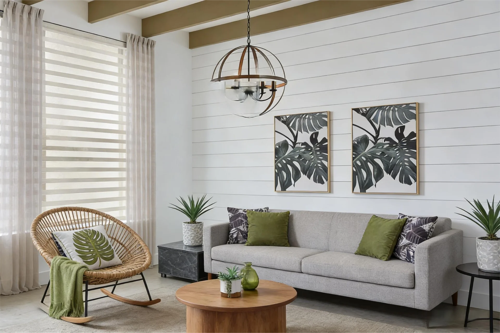 Elegantly decorated living room with a gray sofa, green pillows, and wicker chair. Leaf-patterned artwork and potted plants enhance the design.
